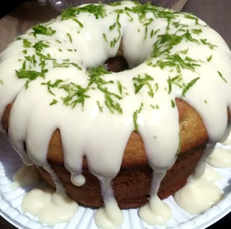 Bolo de limão com cobertura branca e raspas de limão